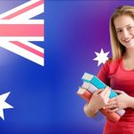 A young woman studies with books as the Australian flag waves, relating to changes in vet sector registration.