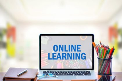 A laptop showing online learning resources with school supplies, highlighting the importance of accessible vet training.