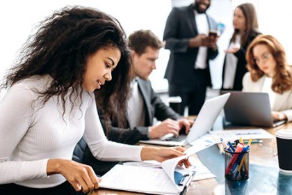 A business team collaborates on vet compliance documents in a modern office.