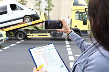 A woman records vehicle damage for an insurance claim, highlighting the importance of video evidence in vet compliance.