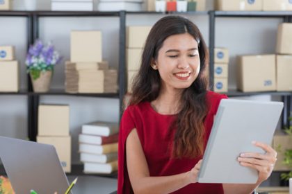 A woman uses a tablet in a modern workspace, focusing on professional success.