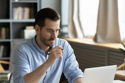 A man works on a laptop, representing vet compliance and the CEO Declaration.