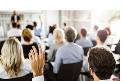 An engaged audience participates in a business seminar discussing VET training.